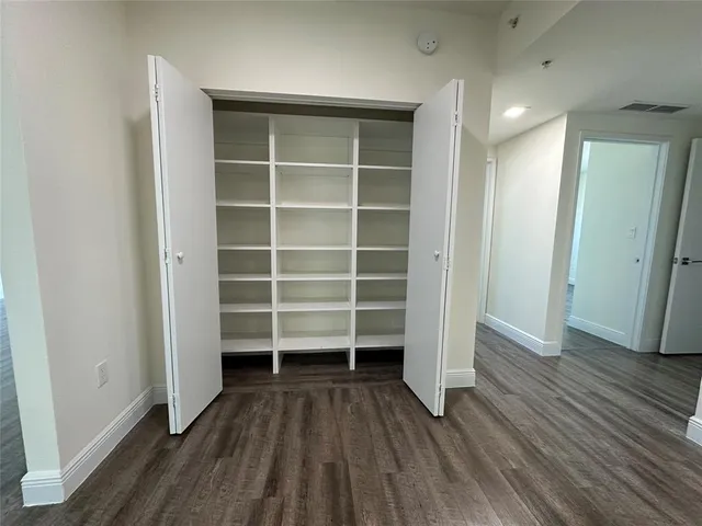 an empty room with wooden floor and closet