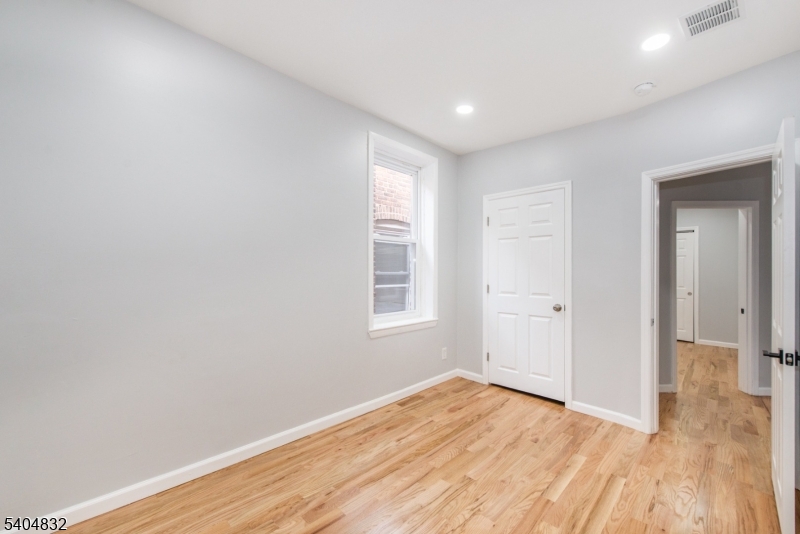 662 Mt Prospect Avenue Newark, NJ 07104 - Photo 11 of 15 a view of empty room with wooden floor and fan