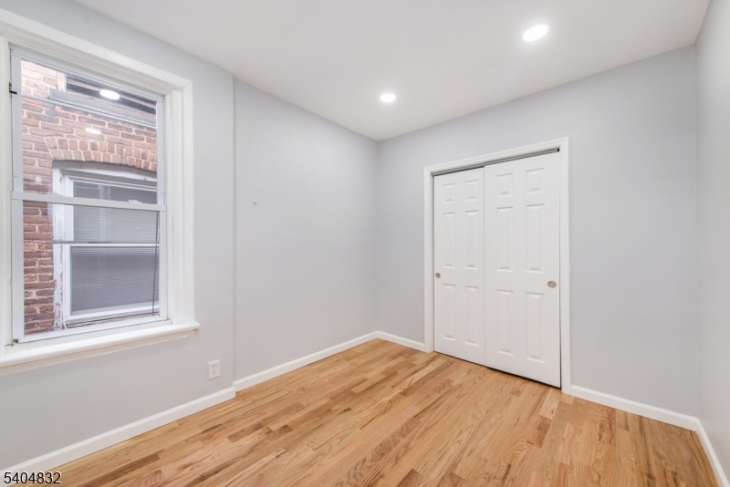 662 Mt Prospect Avenue Newark, NJ 07104 - Photo 12 of 15 a view of empty room with wooden floor and fan
