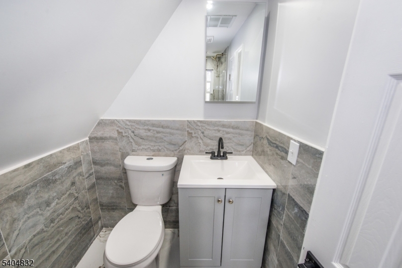 662 Mt Prospect Avenue Newark, NJ 07104 - Photo 13 of 15 a bathroom with a toilet sink and mirror