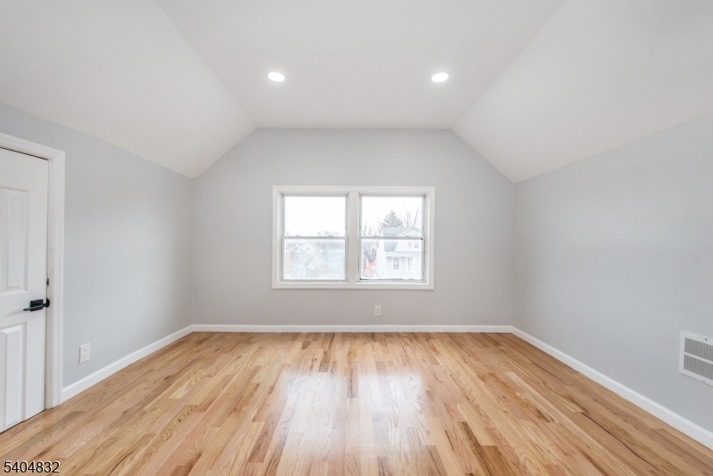 662 Mt Prospect Avenue Newark, NJ 07104 - Photo 14 of 15 an empty room with wooden floor and windows