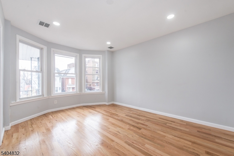662 Mt Prospect Avenue Newark, NJ 07104 - Photo 6 of 15 a view of empty room with wooden floor and fan