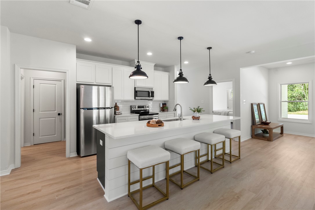 1104 Berkeley Street College Station, TX 77840 - Photo 22 of 44 a kitchen with stainless steel appliances kitchen island granite countertop a refrigerator a stove and white cabinets with wooden floor