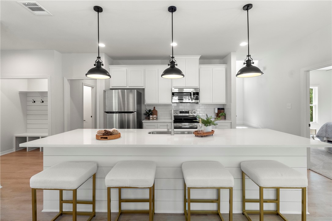 1104 Berkeley Street College Station, TX 77840 - Photo 23 of 44 a kitchen with stainless steel appliances kitchen island granite countertop a table chairs and a sink