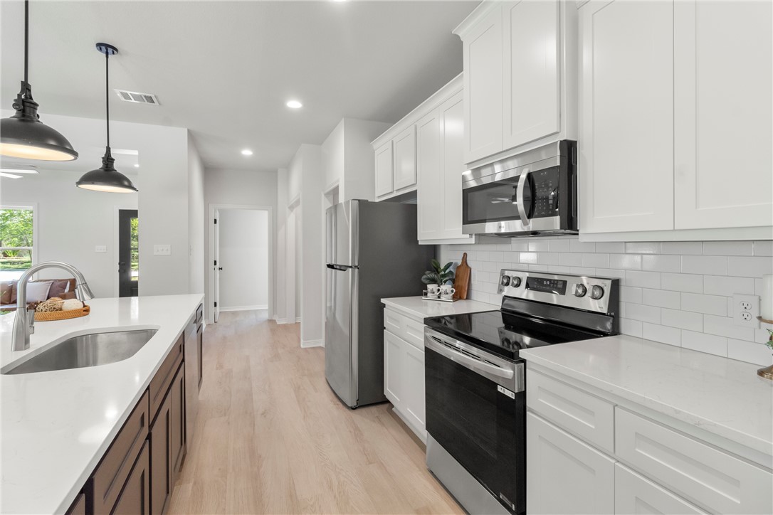1104 Berkeley Street College Station, TX 77840 - Photo 24 of 44 a kitchen with stainless steel appliances a stove sink microwave and cabinets