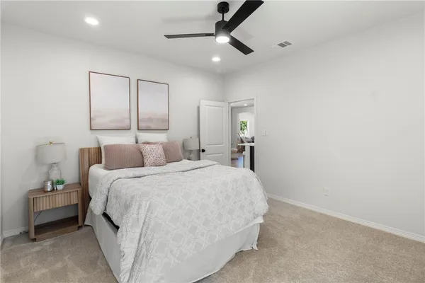 a spacious bedroom with a bed and a lamp