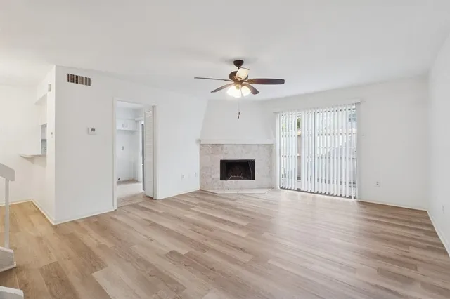 a view of an empty room with a fireplace and a window