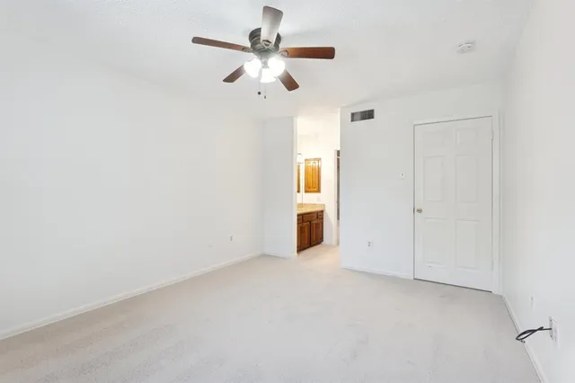 an empty room with chandelier fan