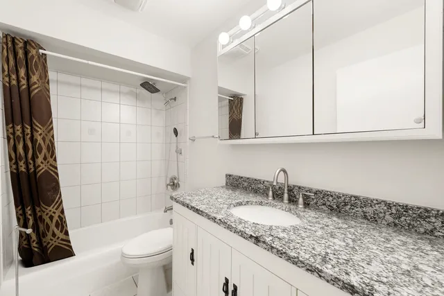 a bathroom with a granite countertop sink and a mirror a bathtub