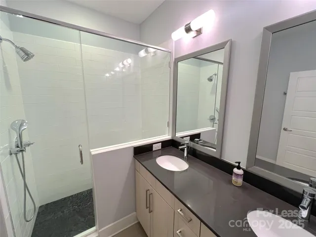 a bathroom with a sink vanity granite tub and shower