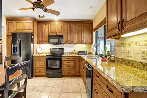 a kitchen with stainless steel appliances granite countertop a stove refrigerator and cabinets