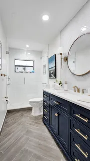 a spacious bathroom with a double vanity sink toilet mirror and bathtub