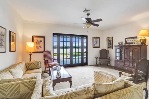 a living room with furniture a ceiling fan and a window