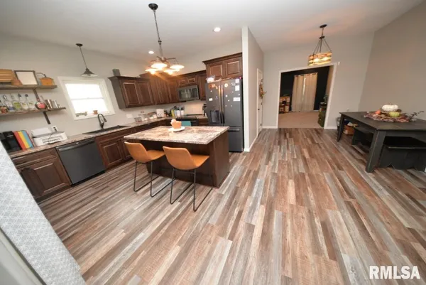 a dining room with wooden floor a chandelier a wooden table and chairs
