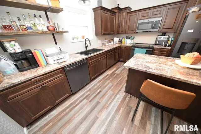 a kitchen with kitchen island granite countertop wooden cabinets a sink and dishwasher