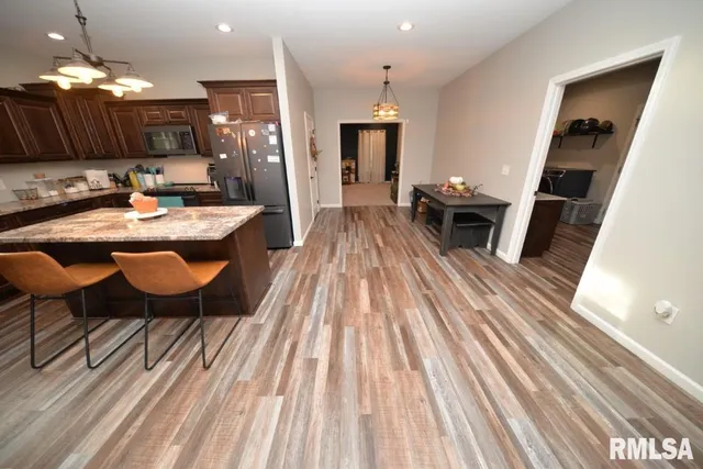 a dining room with furniture a rug kitchen view and a chandelier