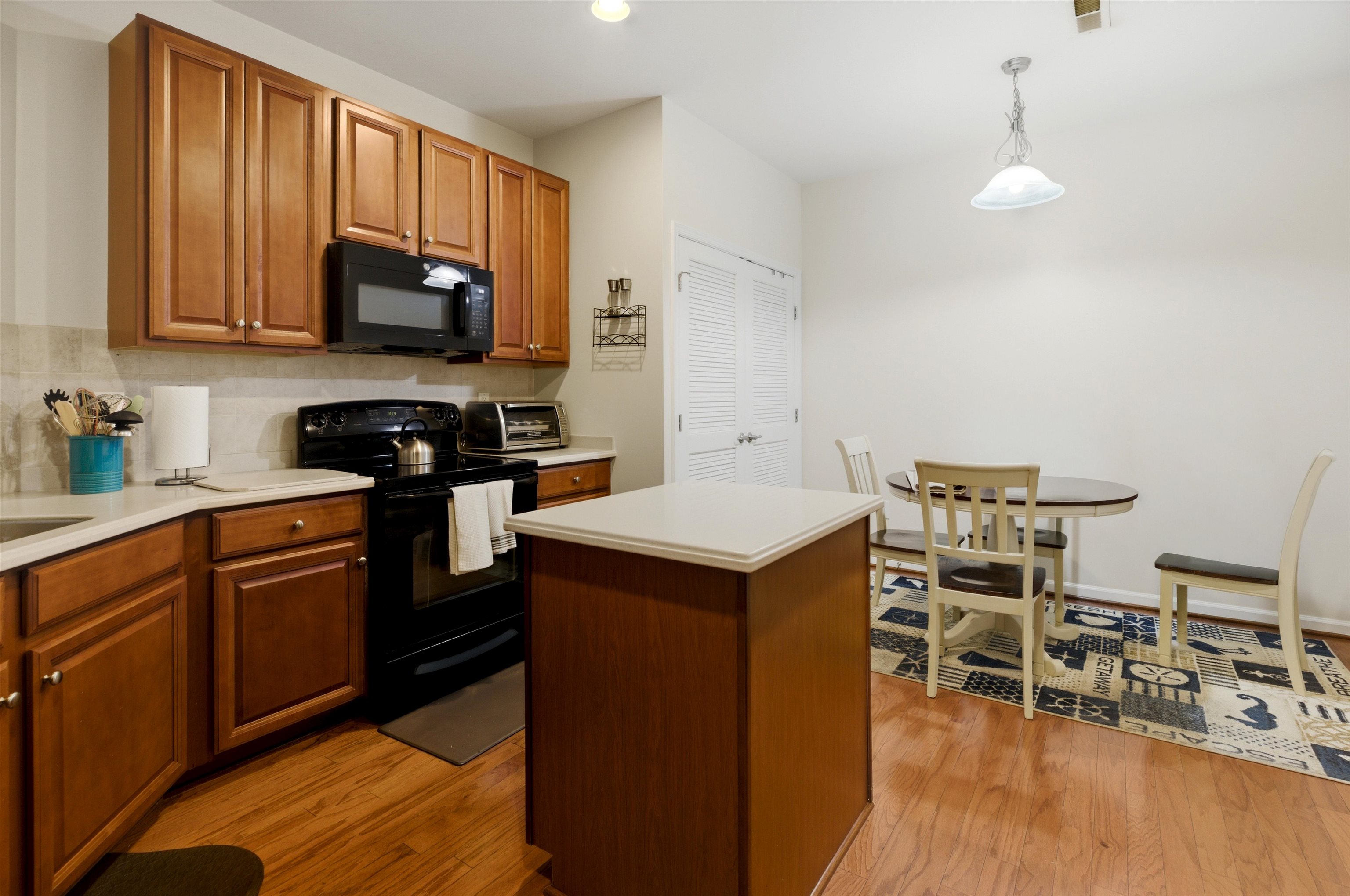 2305 Tidewater Avenue, Unit 2305 Rio Grande, NJ 08242 - Photo 7 of 23 a kitchen with stainless steel appliances a stove a sink a microwave and wooden cabinets