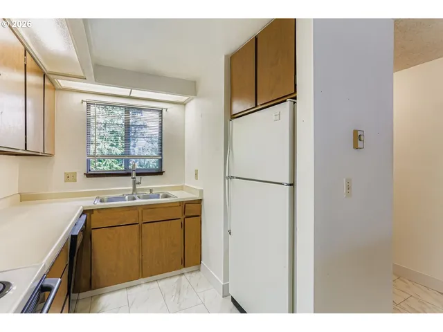a kitchen with a sink a stove cabinets and a window