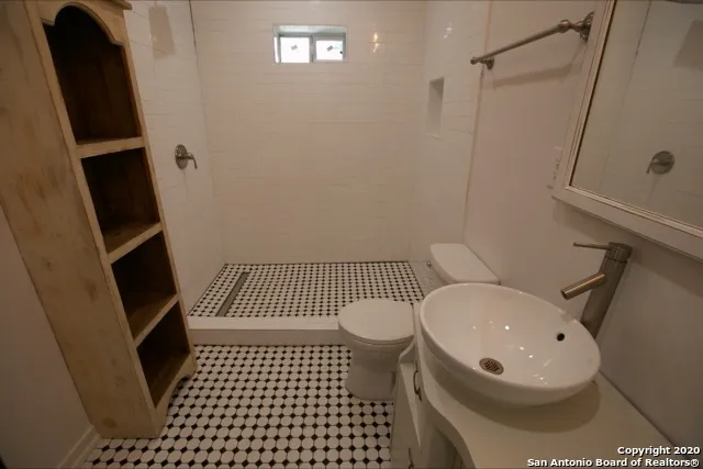 a bathroom with a toilet a sink and mirror
