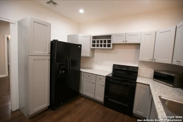 a kitchen with granite countertop a refrigerator and a stove