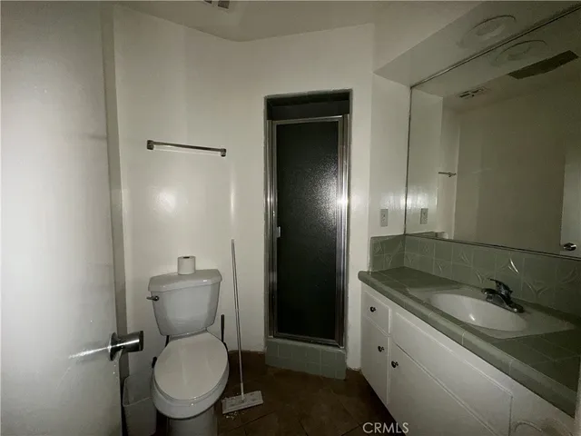 a bathroom with a granite countertop toilet sink and shower