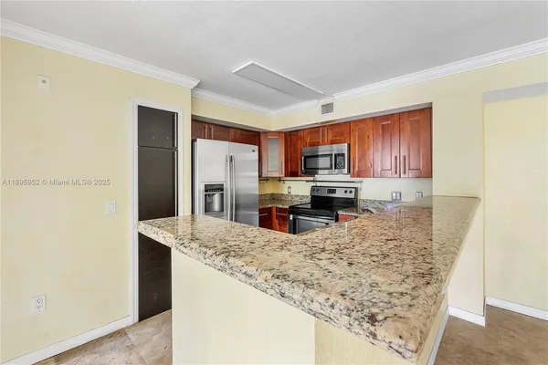 a kitchen with stainless steel appliances granite countertop a refrigerator a stove and a sink with wooden cabinets