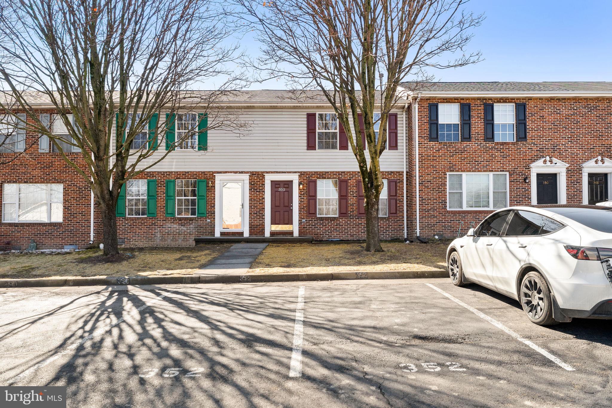 a white house that has a tree on side of it