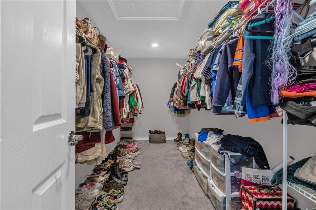 3470 Beau Road Kissimmee, FL 34746 - Photo 20 of 40 a view of walk in closet with clothes and shoes