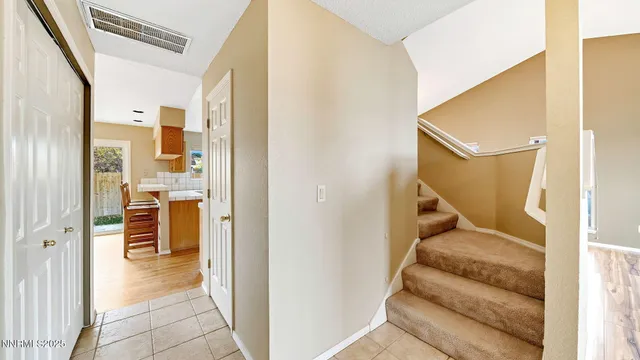 a view of a hallway with staircase and door