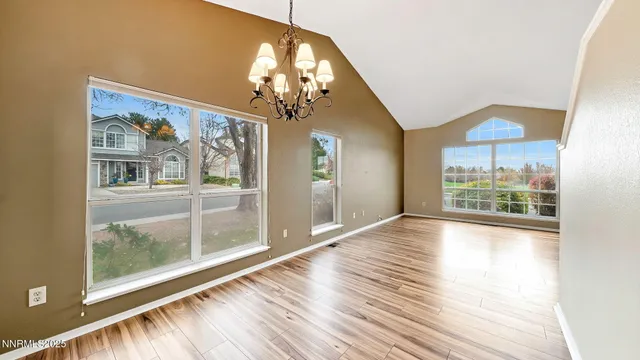 a view of a room with wooden floor and large windows