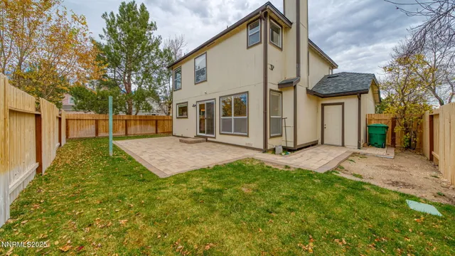a view of backyard with potted plants and wooden fence