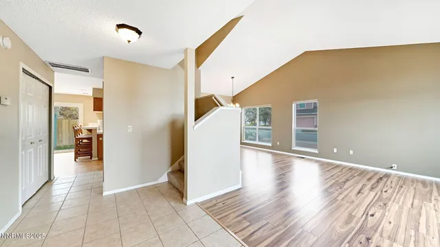 a view of a hallway with wooden floor and a bathroom