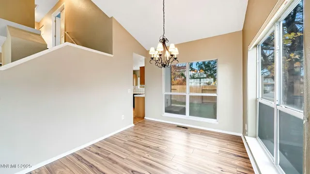 a view of a bedroom with wooden floor and windows
