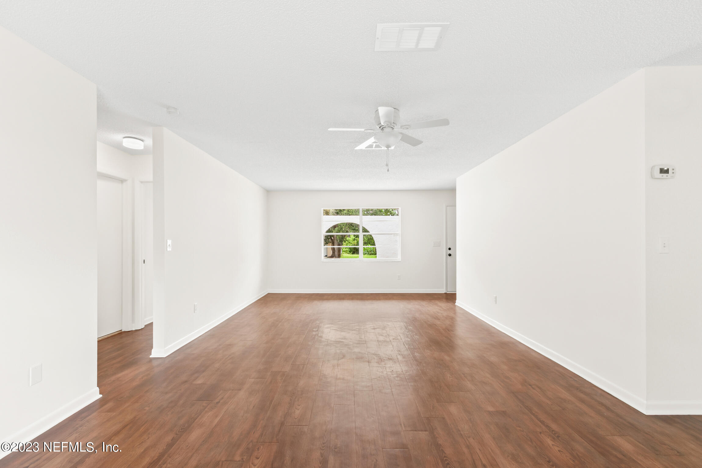 968 Espinado Avenue St. Augustine, FL 32086 - Photo 14 of 41 an empty room with wooden floor chandelier fan and windows
