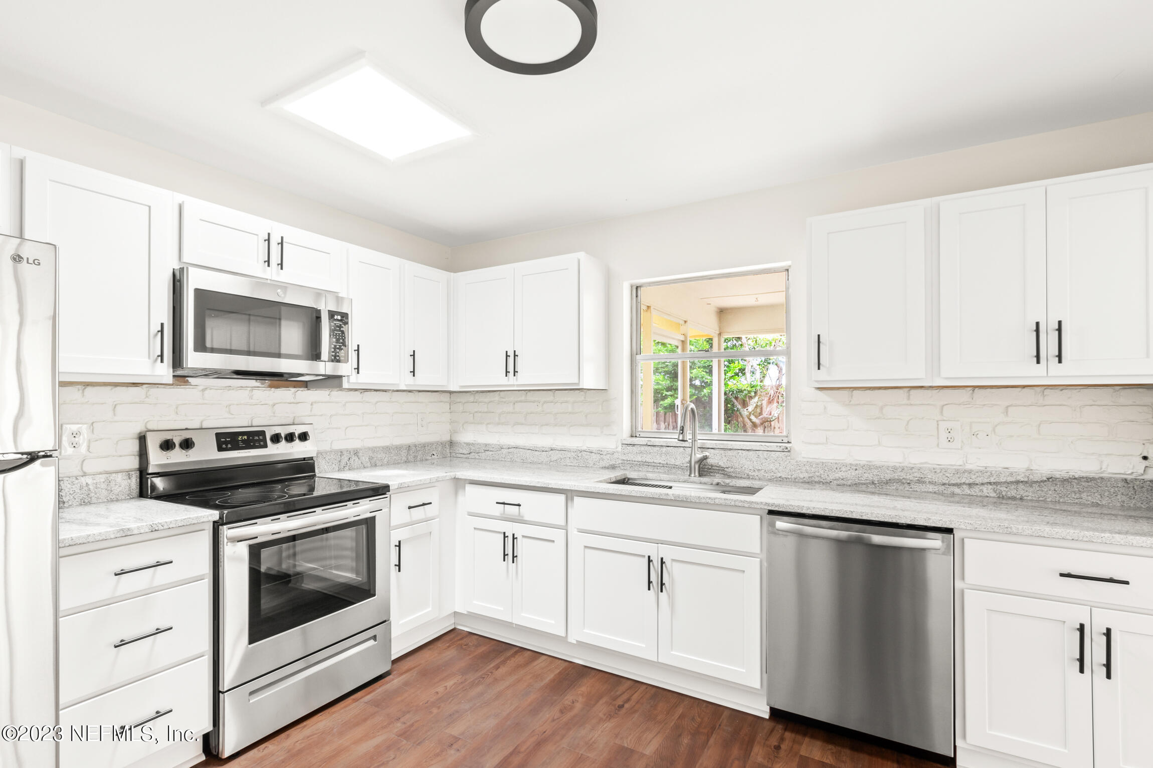 968 Espinado Avenue St. Augustine, FL 32086 - Photo 8 of 41 a kitchen with white cabinets white stainless steel appliances and sink