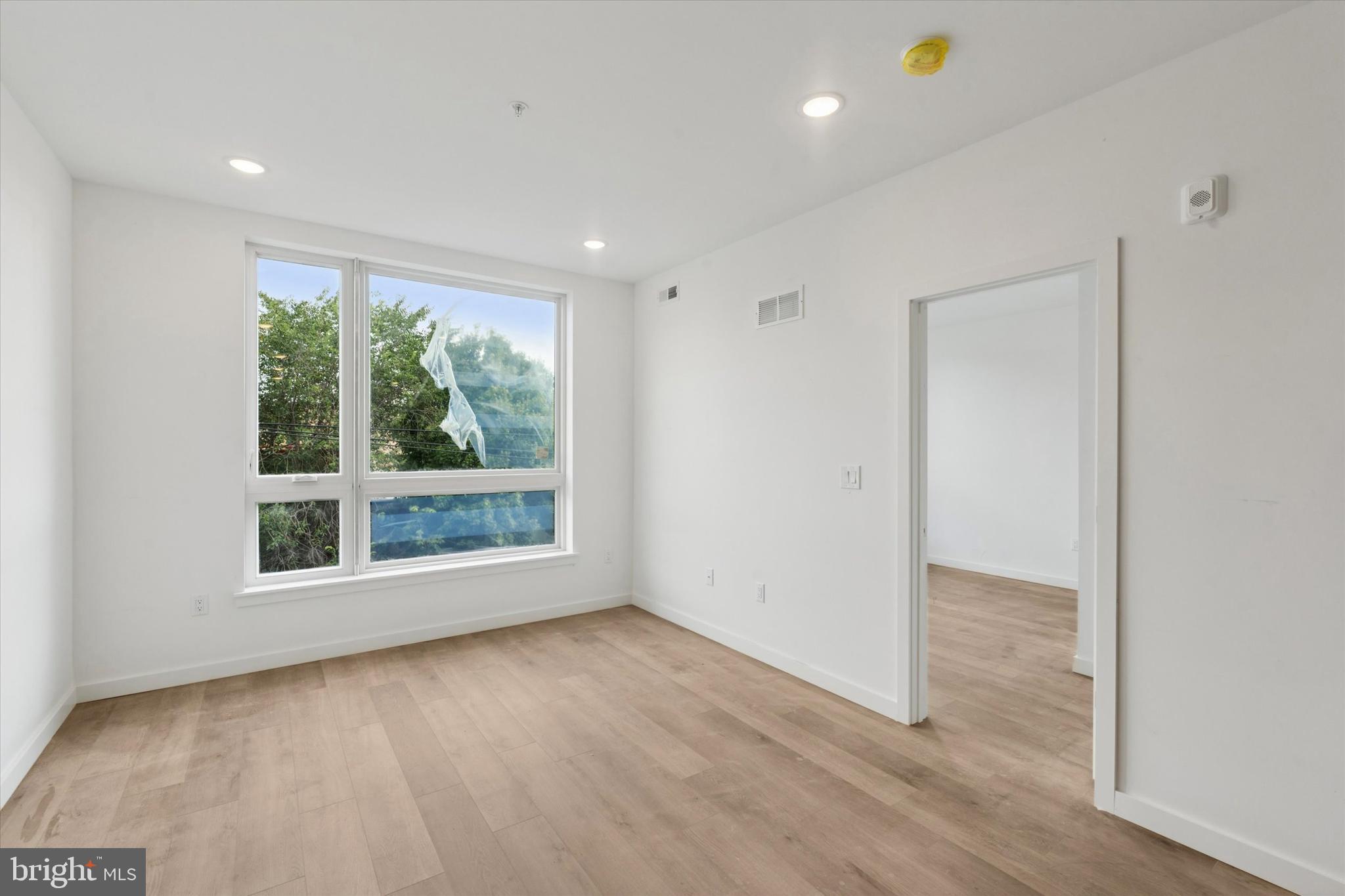754 South 4th Street, Unit 203 Philadelphia, PA 19147 - Photo 6 of 18 a view of an empty room with wooden floor and a window