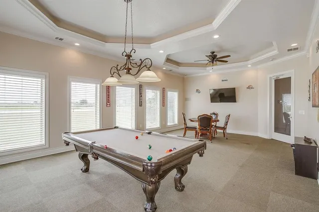 a room with pool table and windows