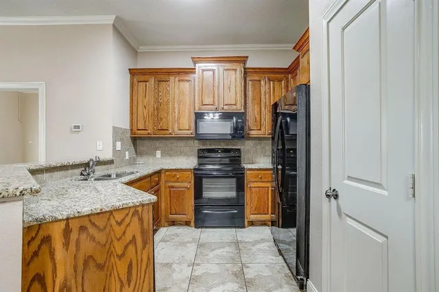 a kitchen with stainless steel appliances granite countertop a refrigerator and a stove top oven