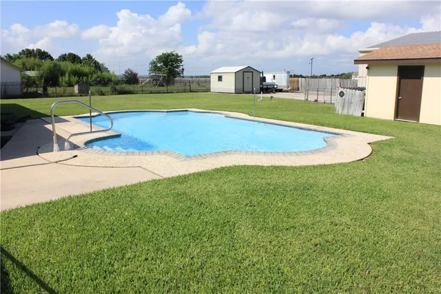 a view of swimming pool is middle in the garden
