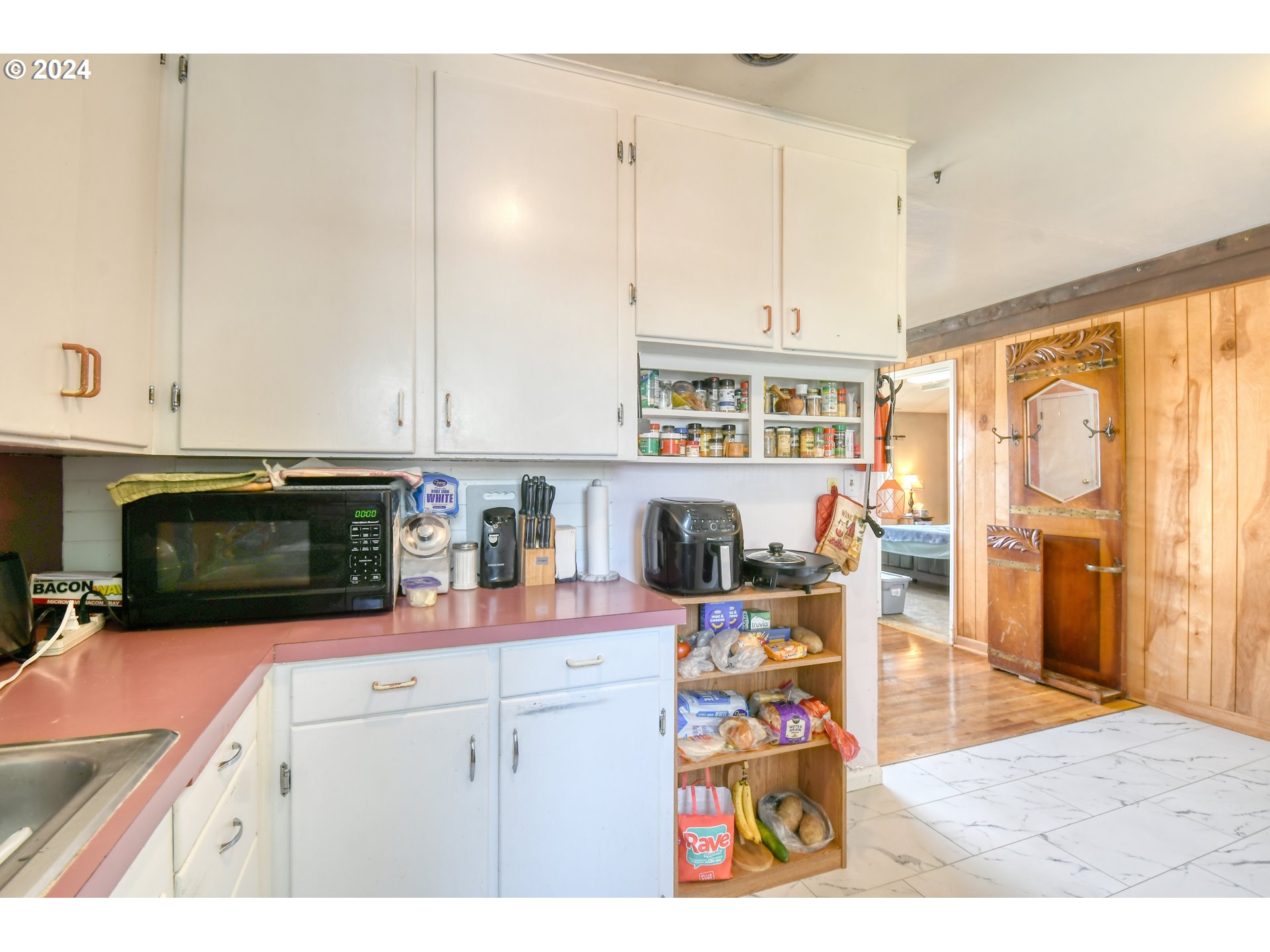 611 Southwest Birch Street Pilot Rock, OR 97868 - Photo 9 of 26 a kitchen with stainless steel appliances granite countertop a stove and white cabinets with wooden floor