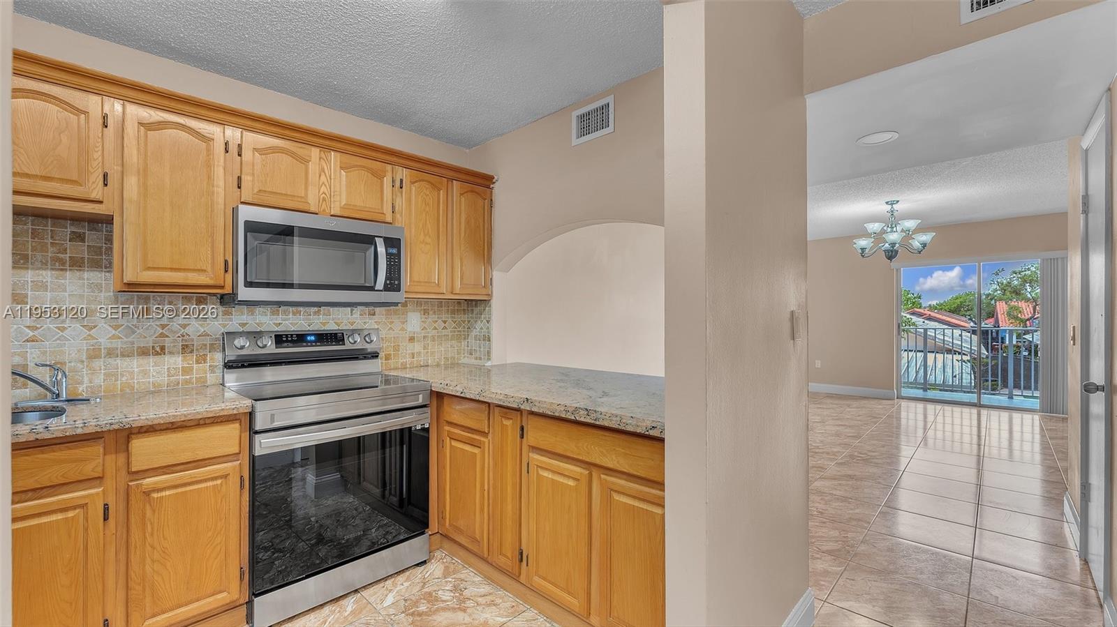 2780 West 76th Street, Unit 203 Hialeah, FL 33016 - Photo 6 of 21 a kitchen with stainless steel appliances granite countertop a stove a sink and a microwave