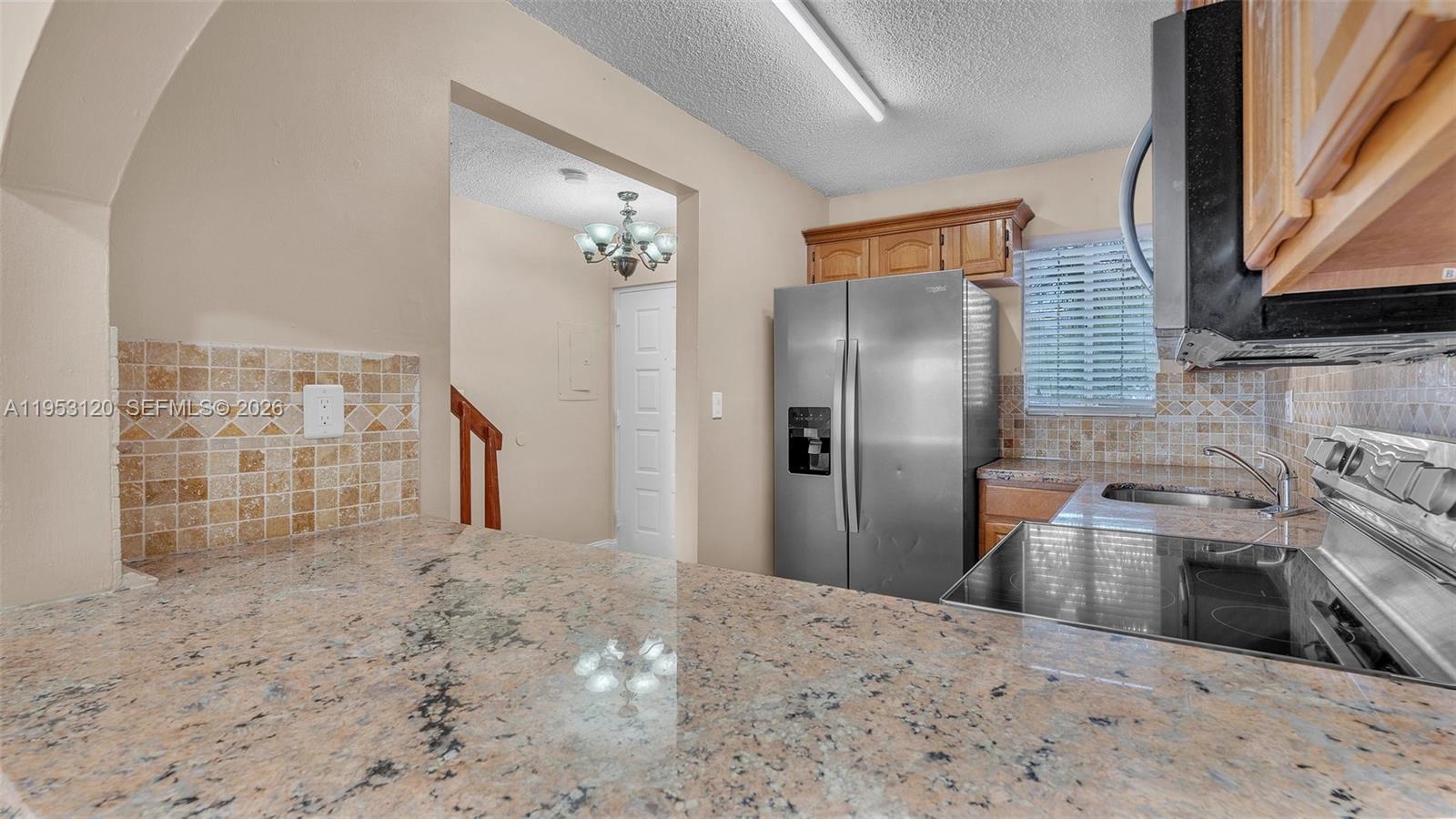 2780 West 76th Street, Unit 203 Hialeah, FL 33016 - Photo 9 of 21 a kitchen with granite countertop a refrigerator and a sink