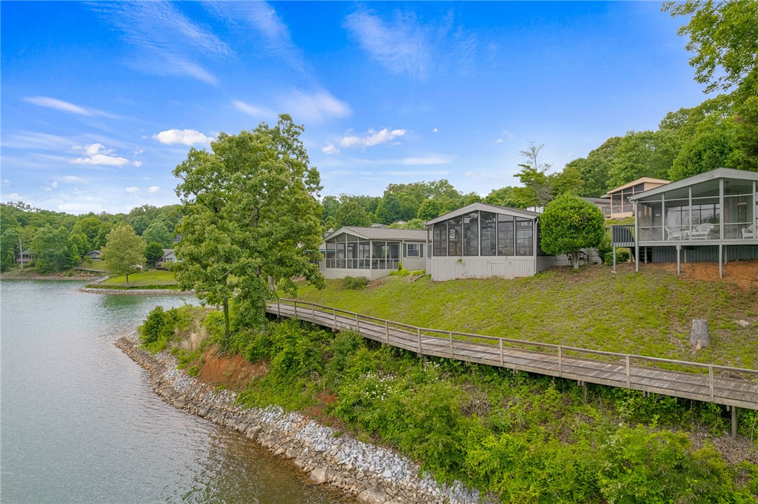 1230 Melton Road, Unit 30 West Union, SC 29696 - Photo 28 of 42 Lakeside residences with screened porches and a wooden walkway, nestled into the verdant hillside.