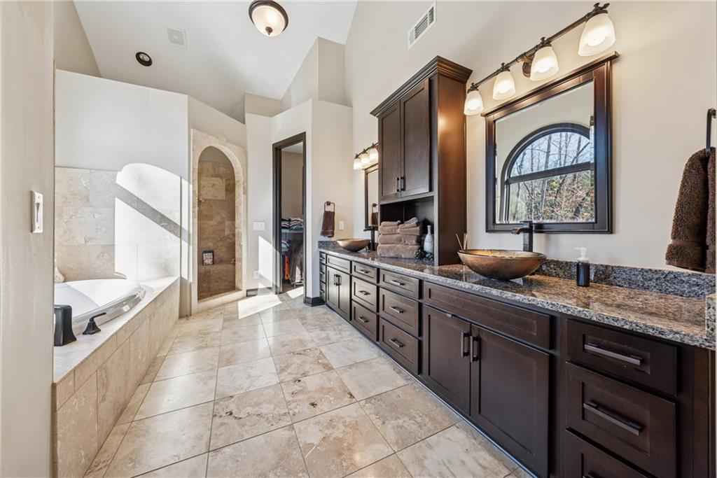 101 Bevil Ridge Road Southeast Emerson, GA 30137 - Photo 24 of 74 a large bathroom with a granite countertop double vanity sink a mirror and a bathtub