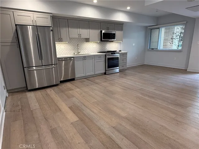 a kitchen with stainless steel appliances granite countertop a stove a sink and a refrigerator