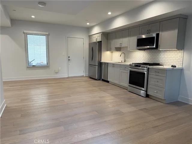 a kitchen with granite countertop a refrigerator and a stove top oven