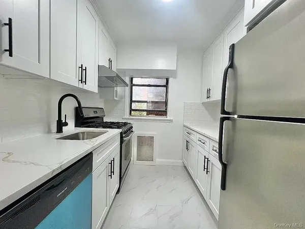 a kitchen with white cabinets sink and stainless steel appliances