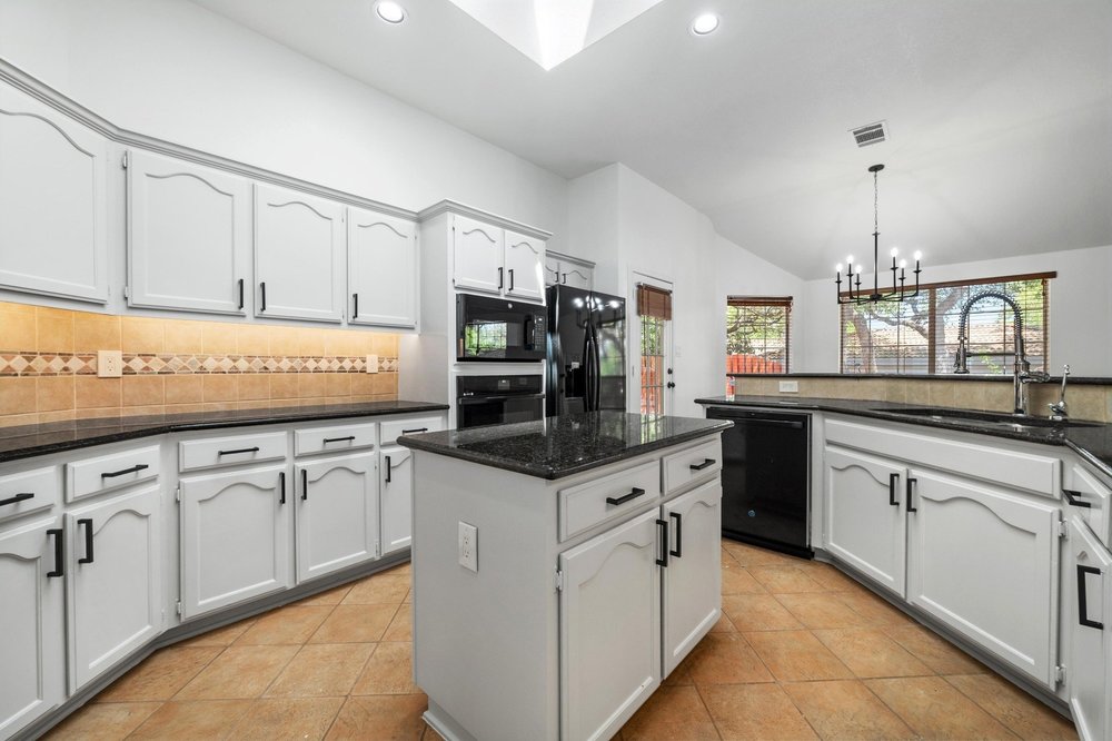 209 El Rio Drive Lakeway, TX 78734 - Photo 15 of 40 a kitchen with granite countertop a sink stove and cabinets