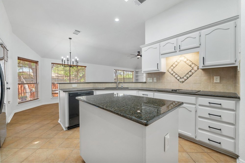 209 El Rio Drive Lakeway, TX 78734 - Photo 16 of 40 a kitchen with granite countertop a sink and a stove