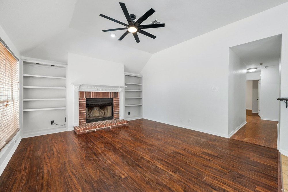 209 El Rio Drive Lakeway, TX 78734 - Photo 19 of 40 a view of empty room with wooden floor and fireplace